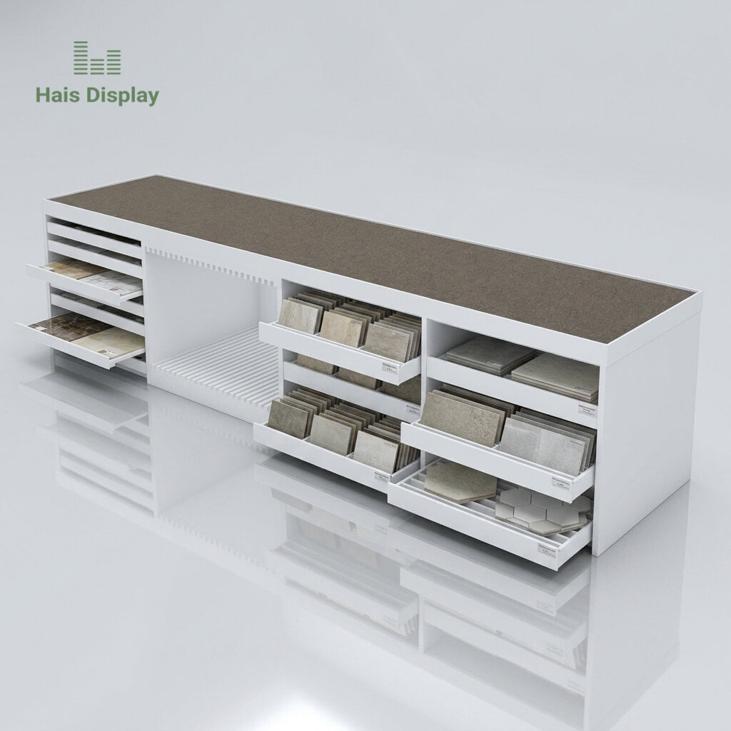 Multi-functional tile display island table with pull out drawers for ceramic and stone samples in white showroom setting